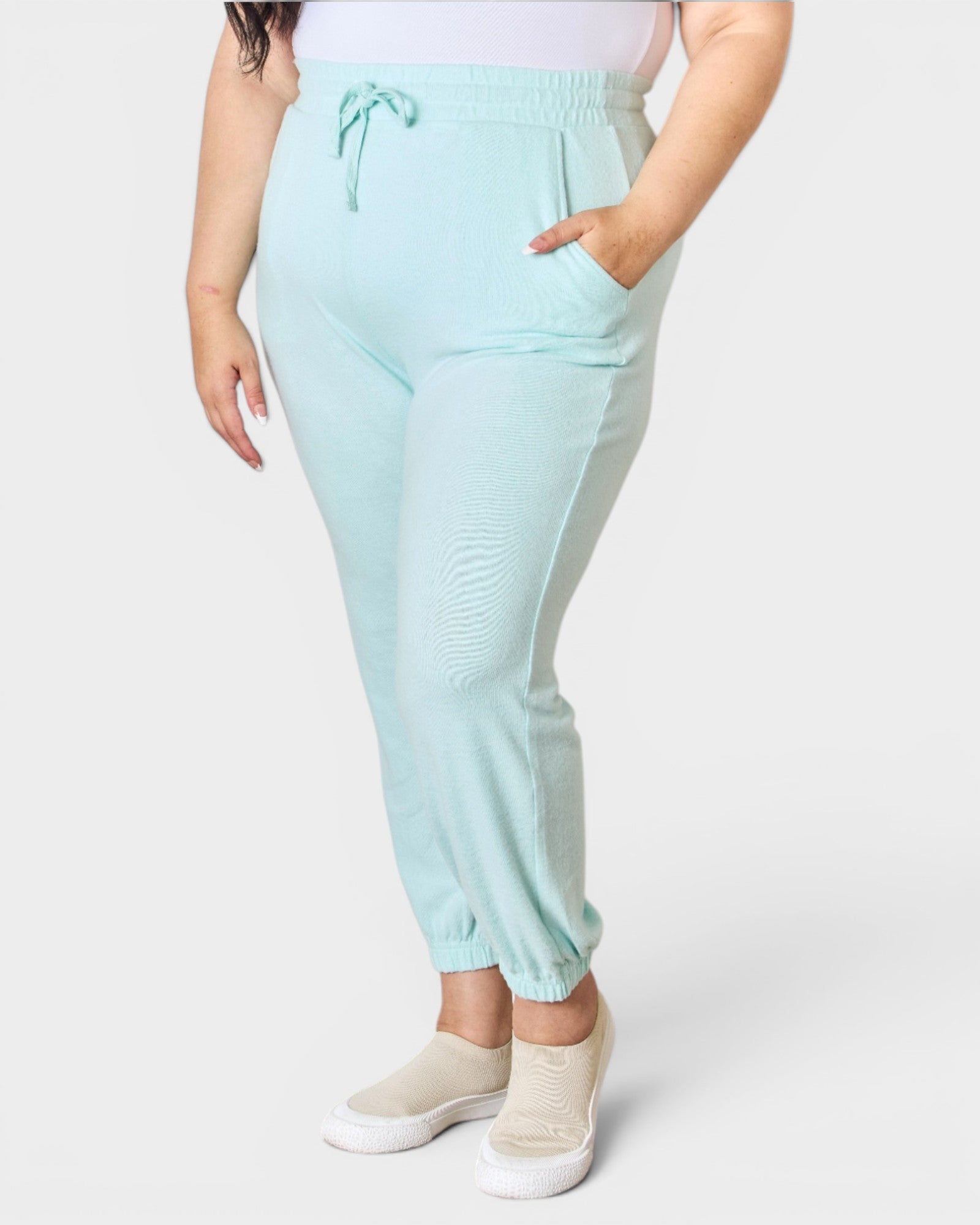 Light blue jogger pants worn by a person on a white background