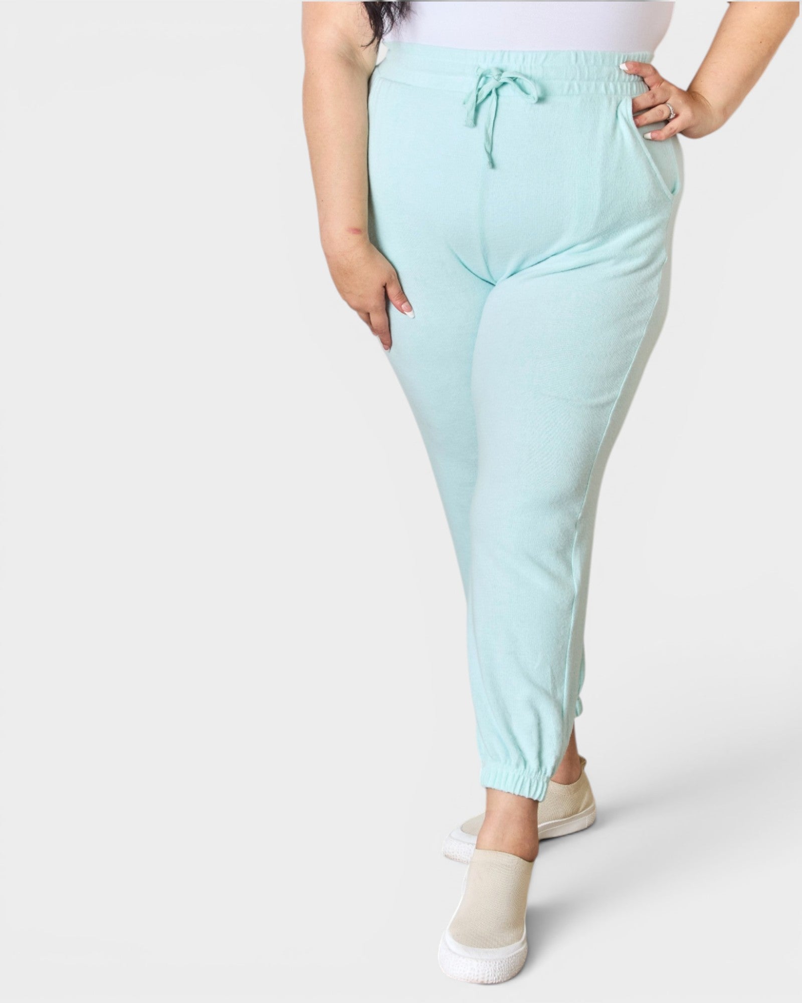 Light blue jogger pants worn by a person on a white background