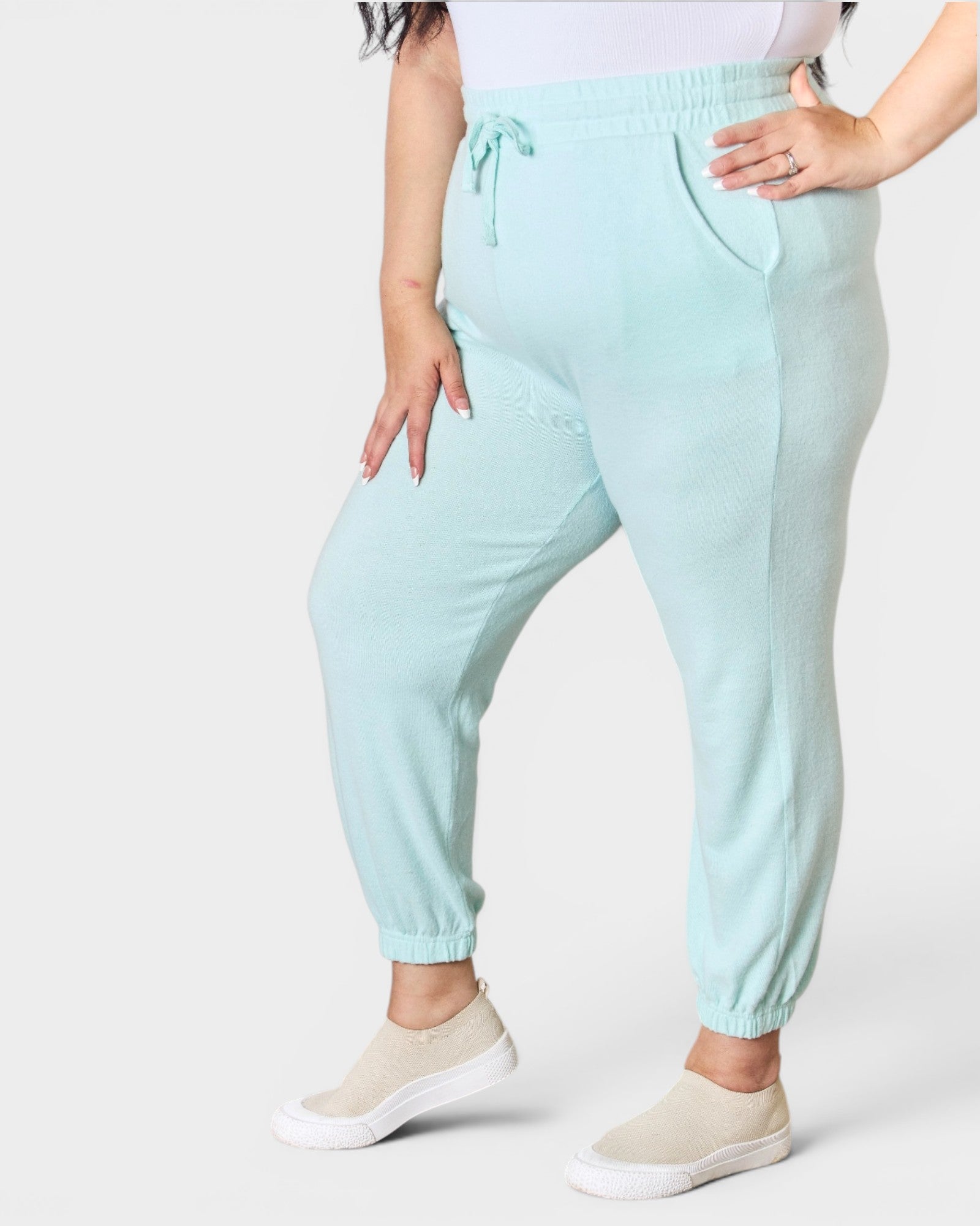 Light blue jogger pants worn by a person on a white background