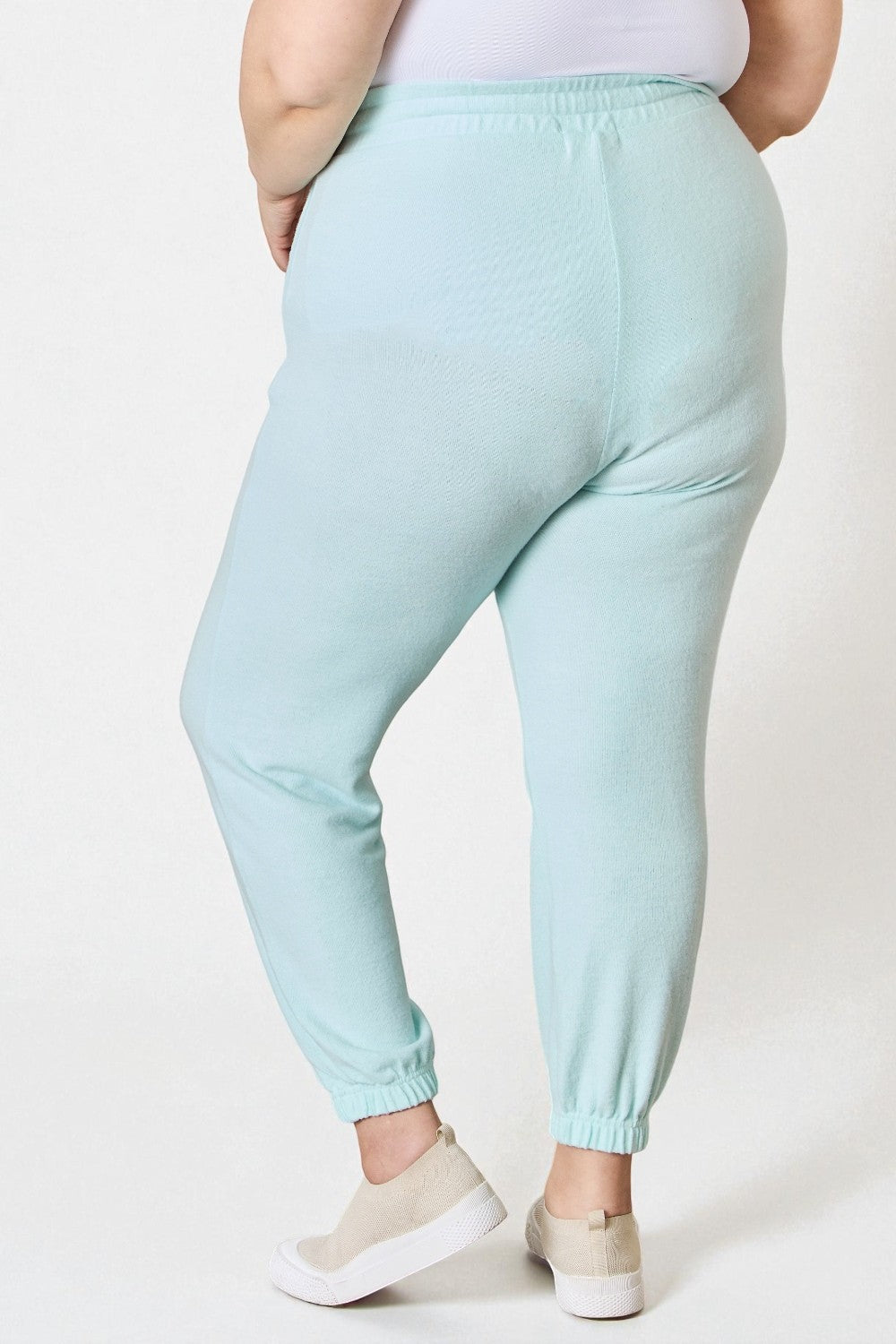 Light blue jogger pants worn by a person on a white background