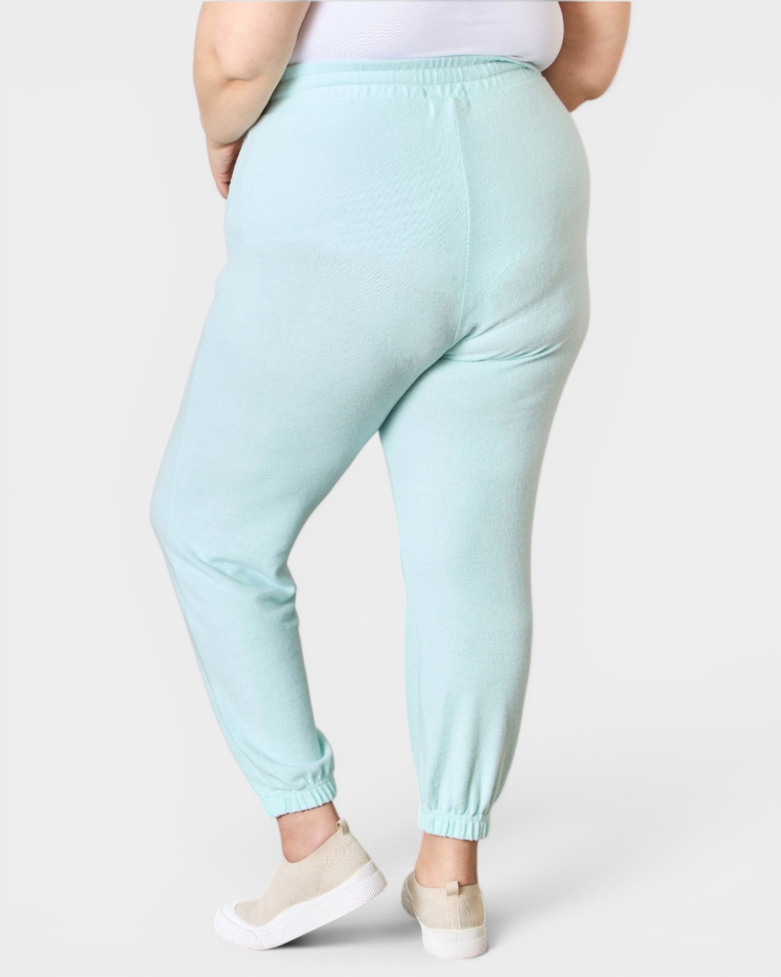 Light blue jogger pants worn by a person on a white background