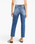 A person shown from the back wearing medium-wash blue cropped jeans with a white cropped top and brown slide sandals against a light gray studio background.