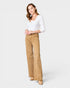 Woman wearing beige pants and a white top on a white background