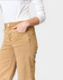 Person wearing beige pants with a white shirt on a plain background