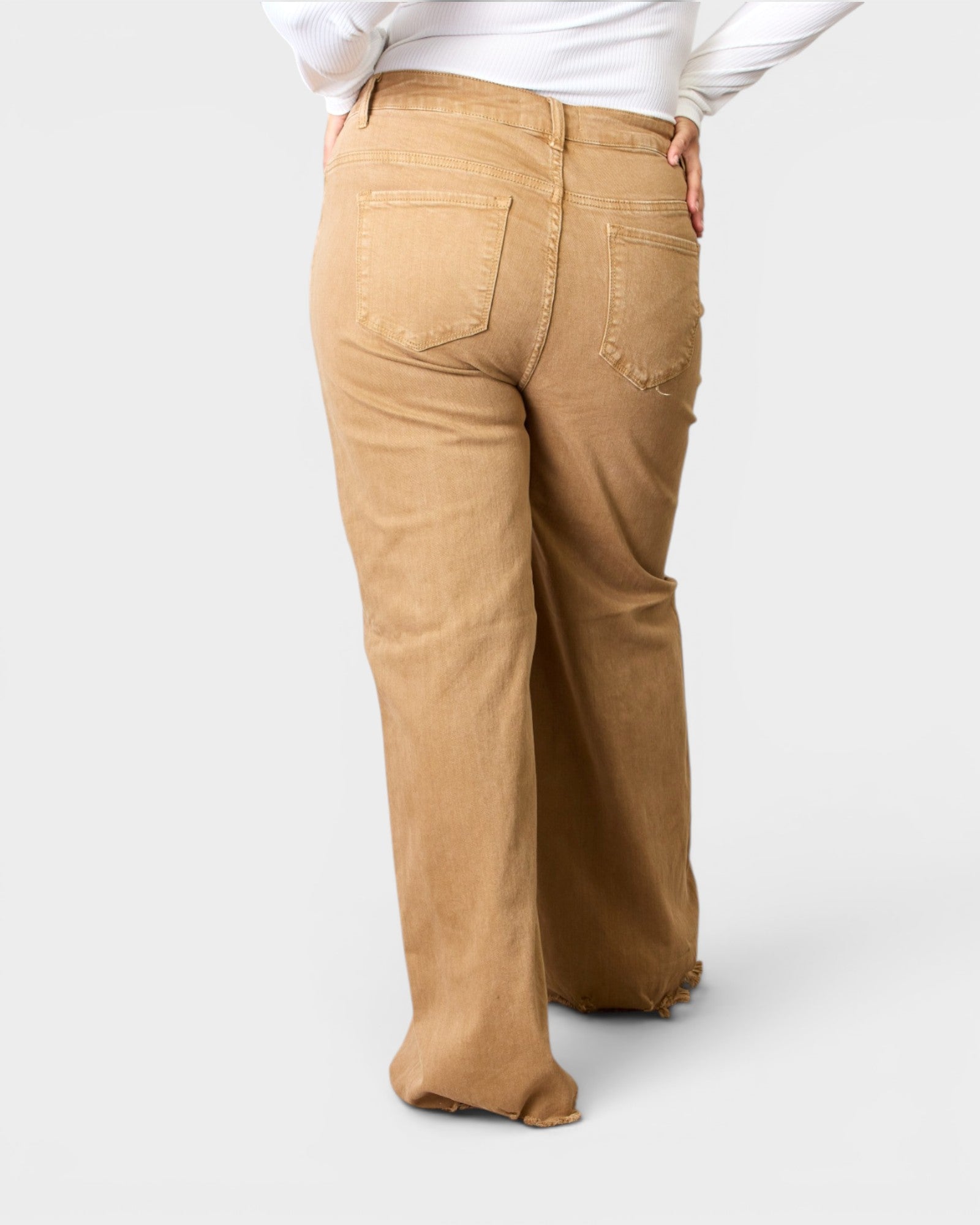 Person wearing tan pants on a white background
