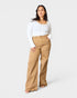 Woman wearing a white top and tan pants on a white background