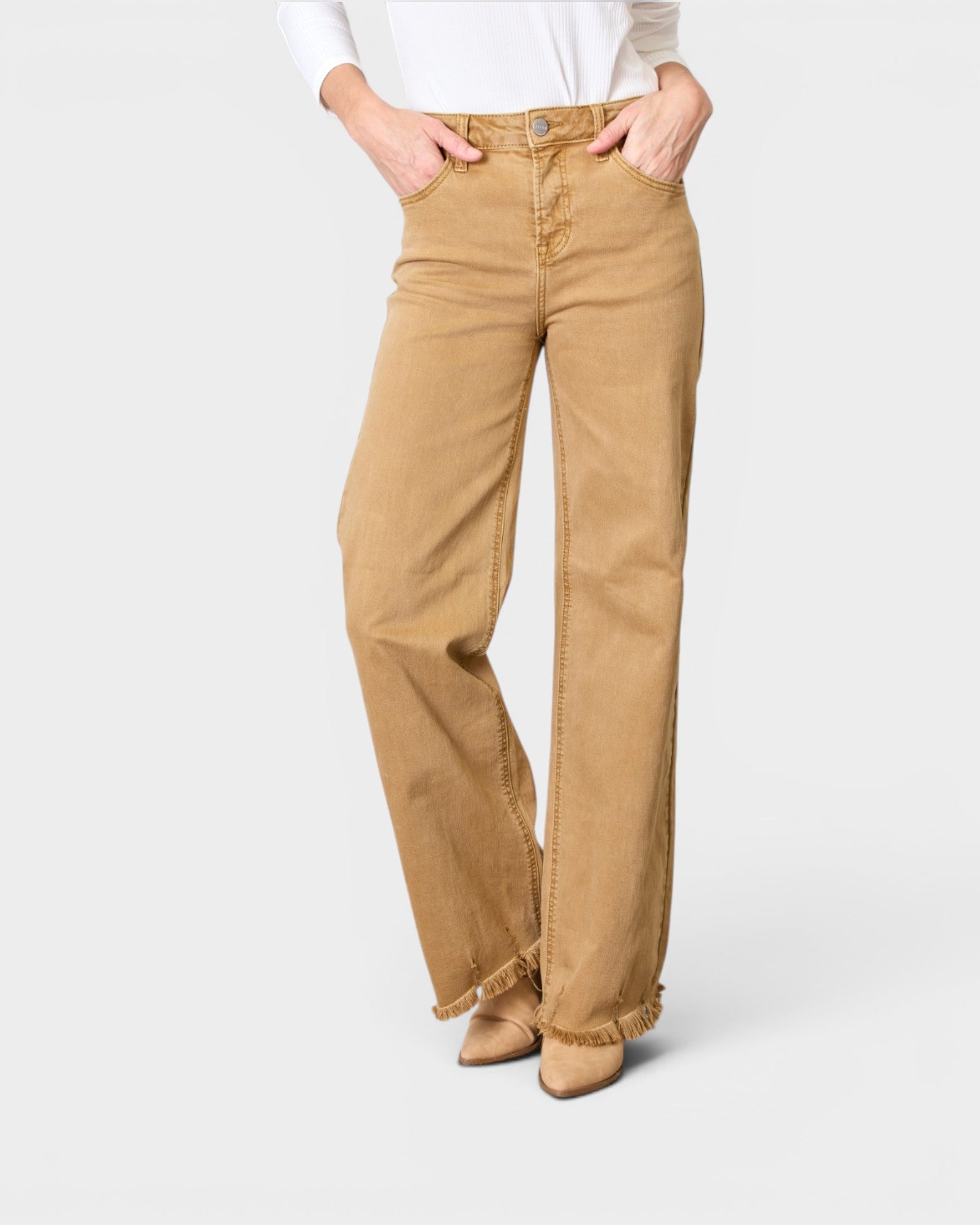 Person wearing tan flared jeans on a white background