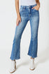 Person wearing blue jeans and white boots on a plain background