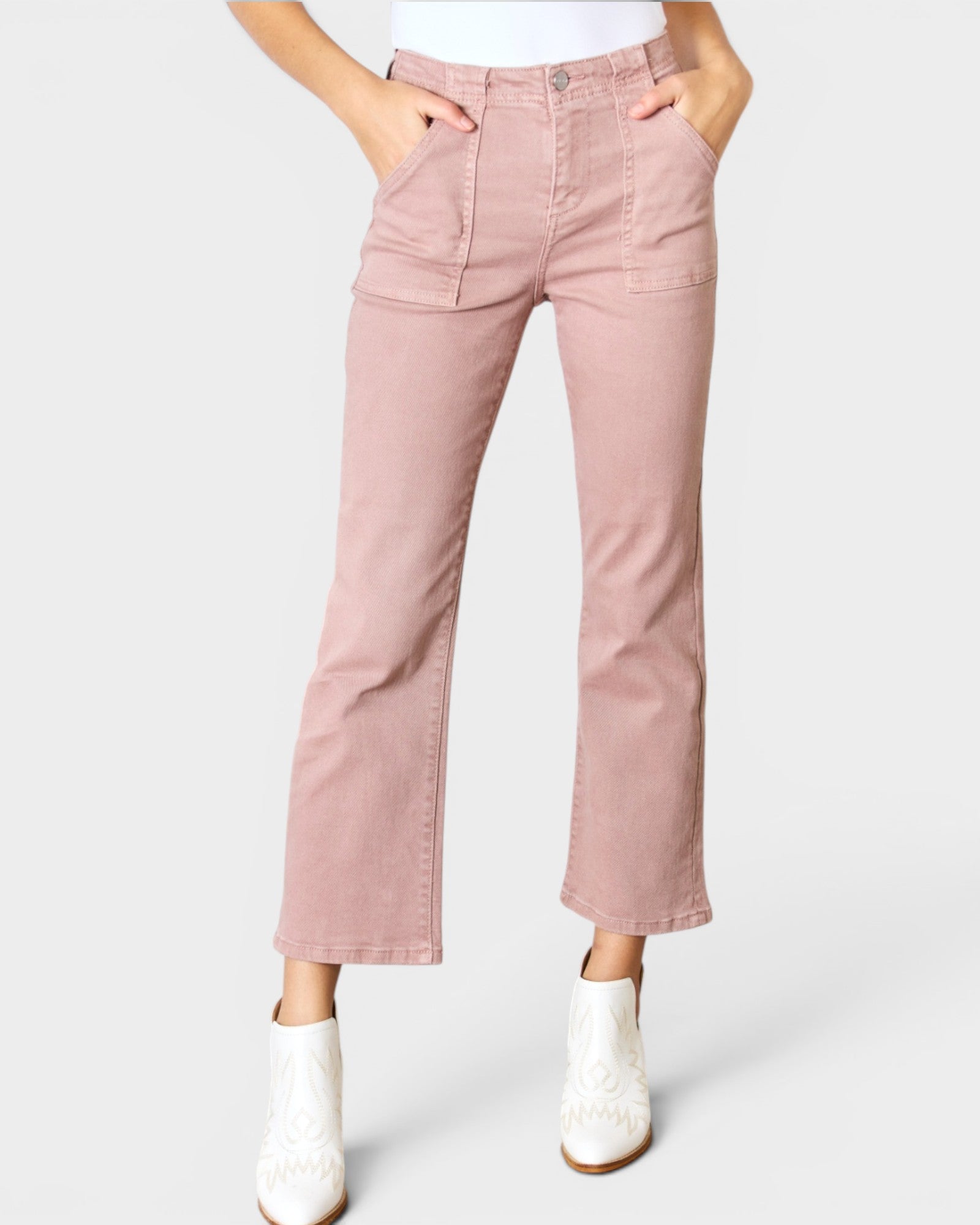 Person wearing pink jeans and white boots on a white background