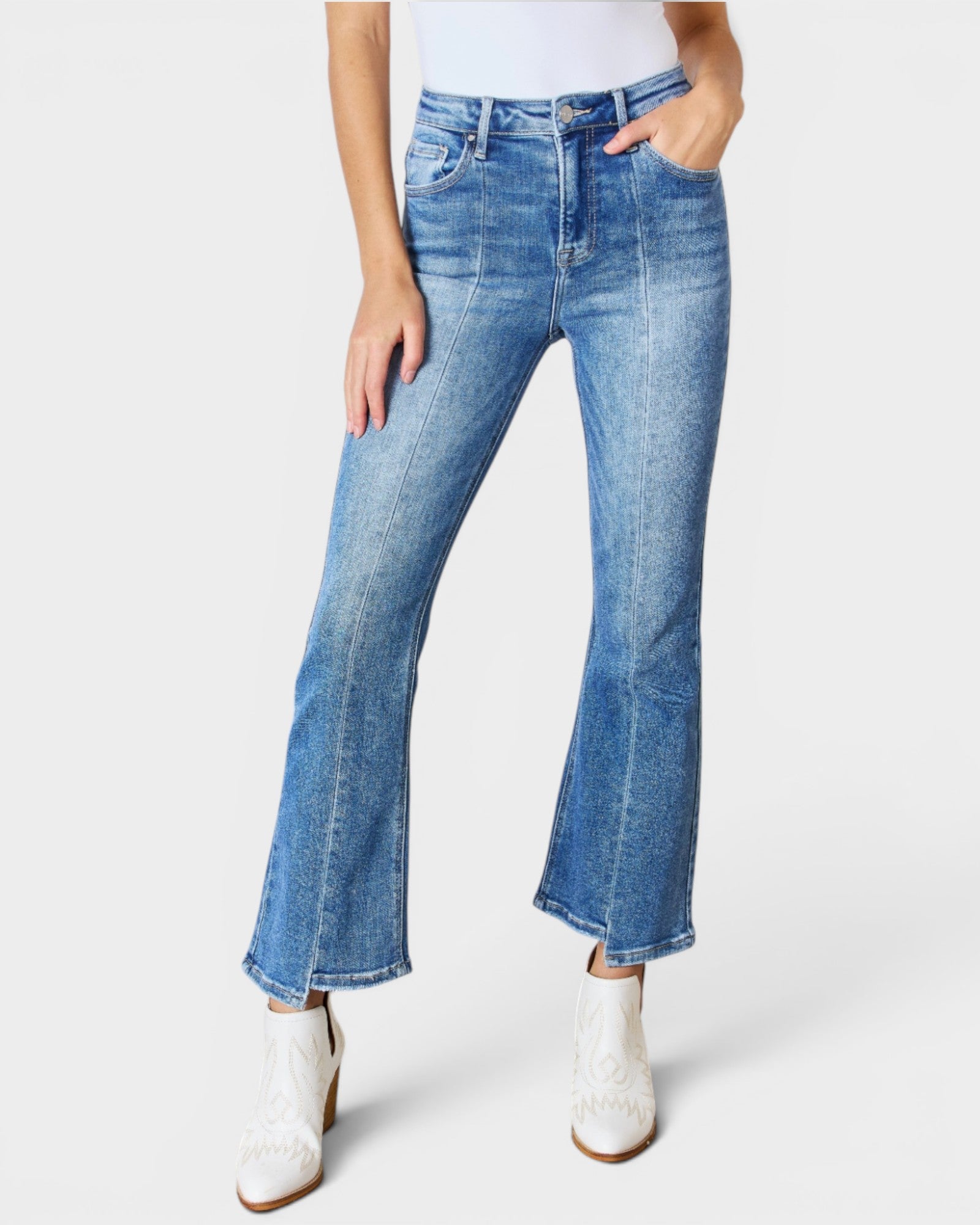 Person wearing blue flared jeans on a white background