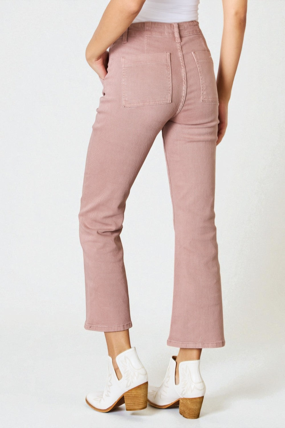 Person wearing pink pants and white shoes on a white background