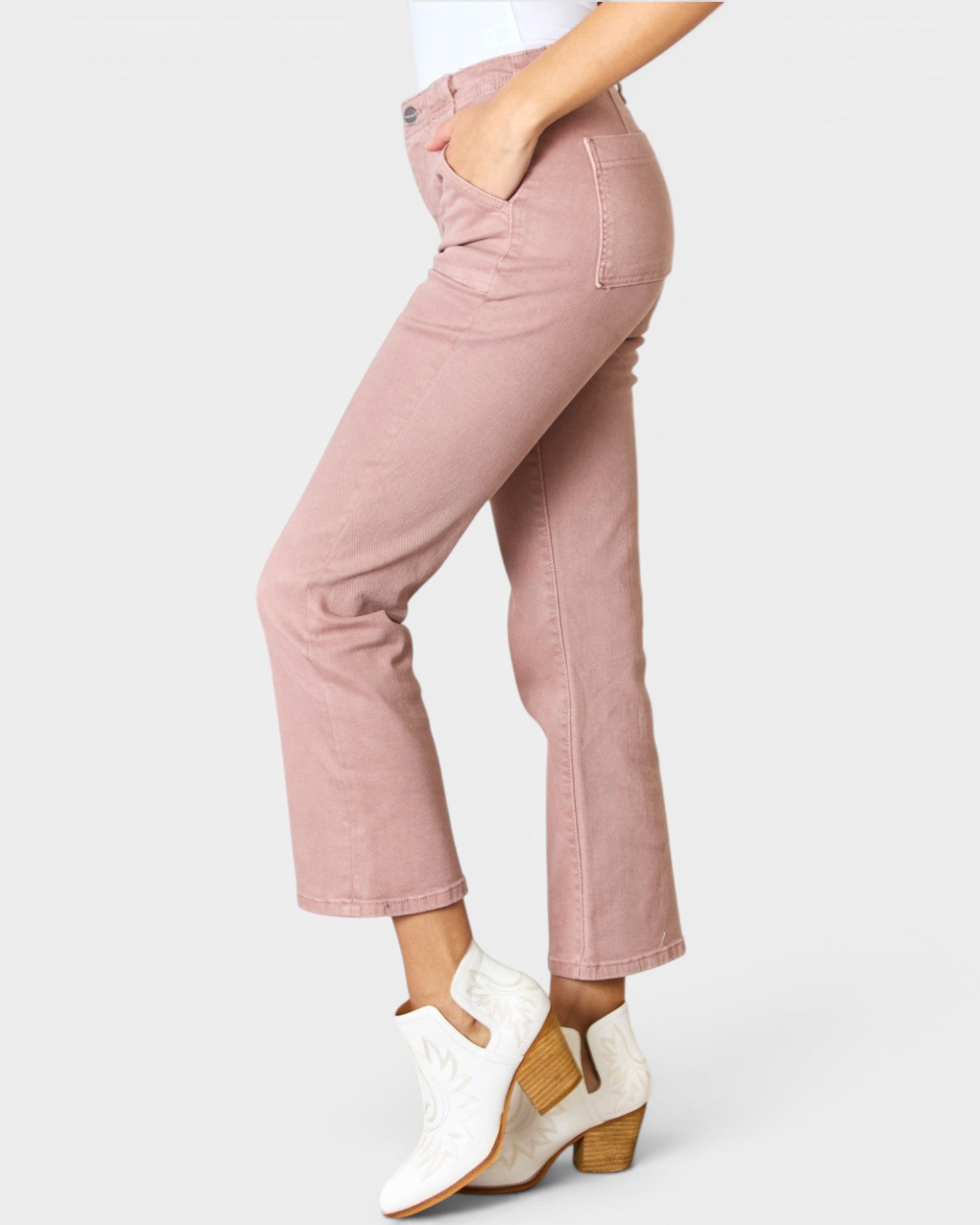 Pink jeans worn by a person on a white background