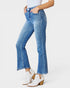 Person wearing blue jeans and white cowboy boots on a white background