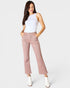 Woman wearing a white top and pink pants on a white background