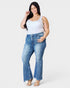 Woman wearing blue jeans and a white tank top on a white background