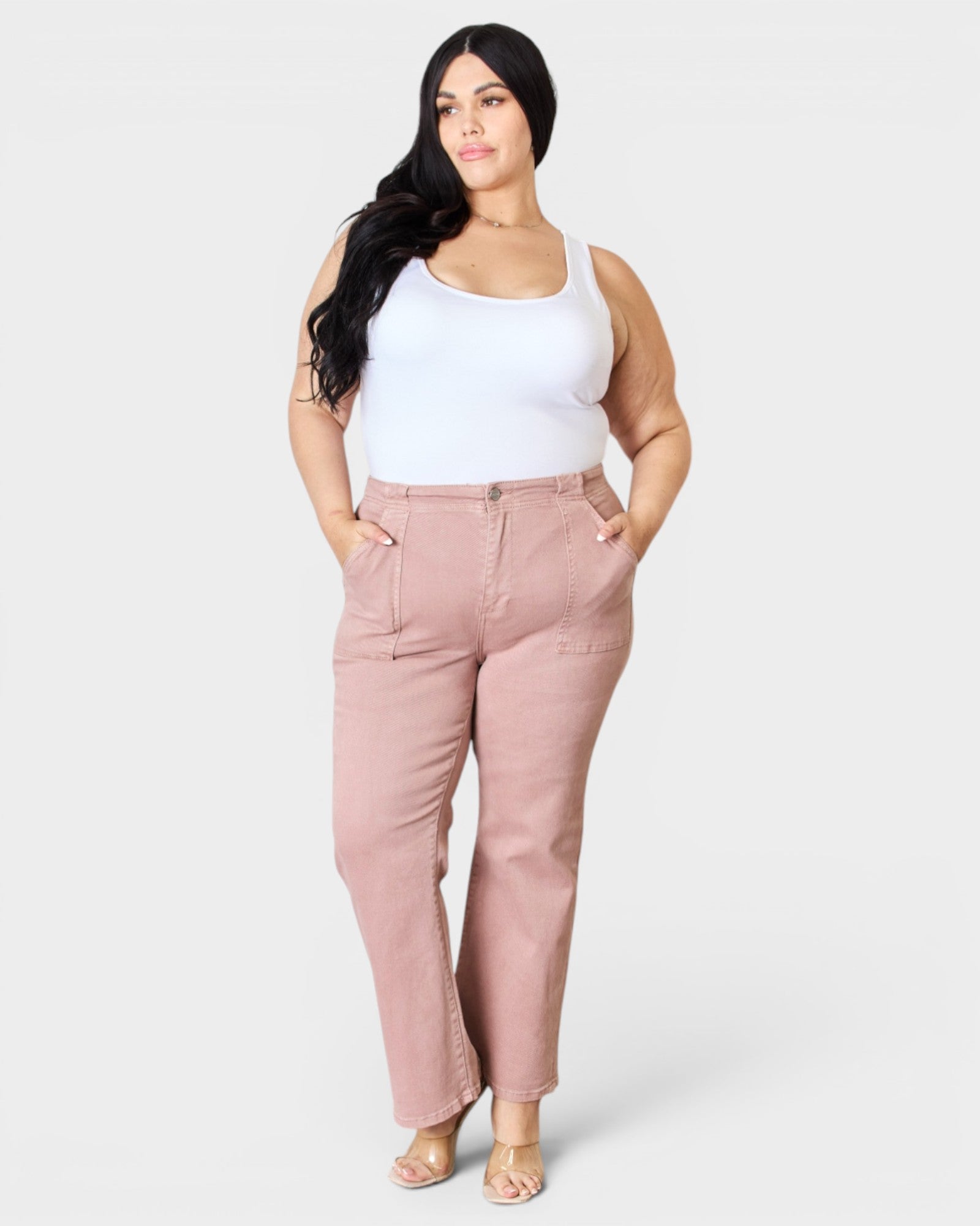 Woman wearing pink pants and a white top on a white background