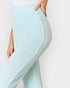 Light blue leggings being held up against a white background