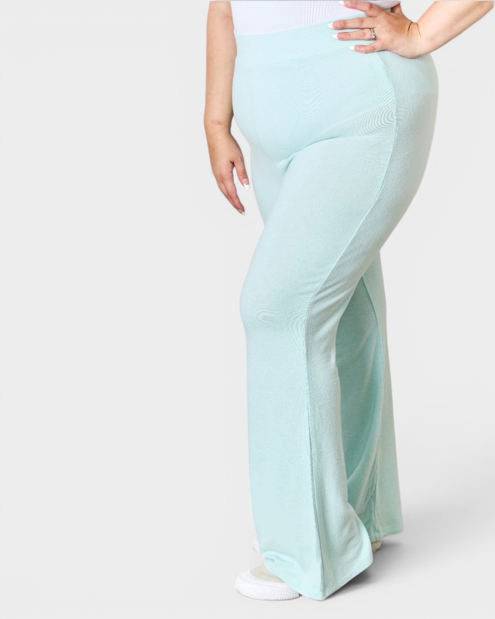Light blue flared pants worn by a person on a white background