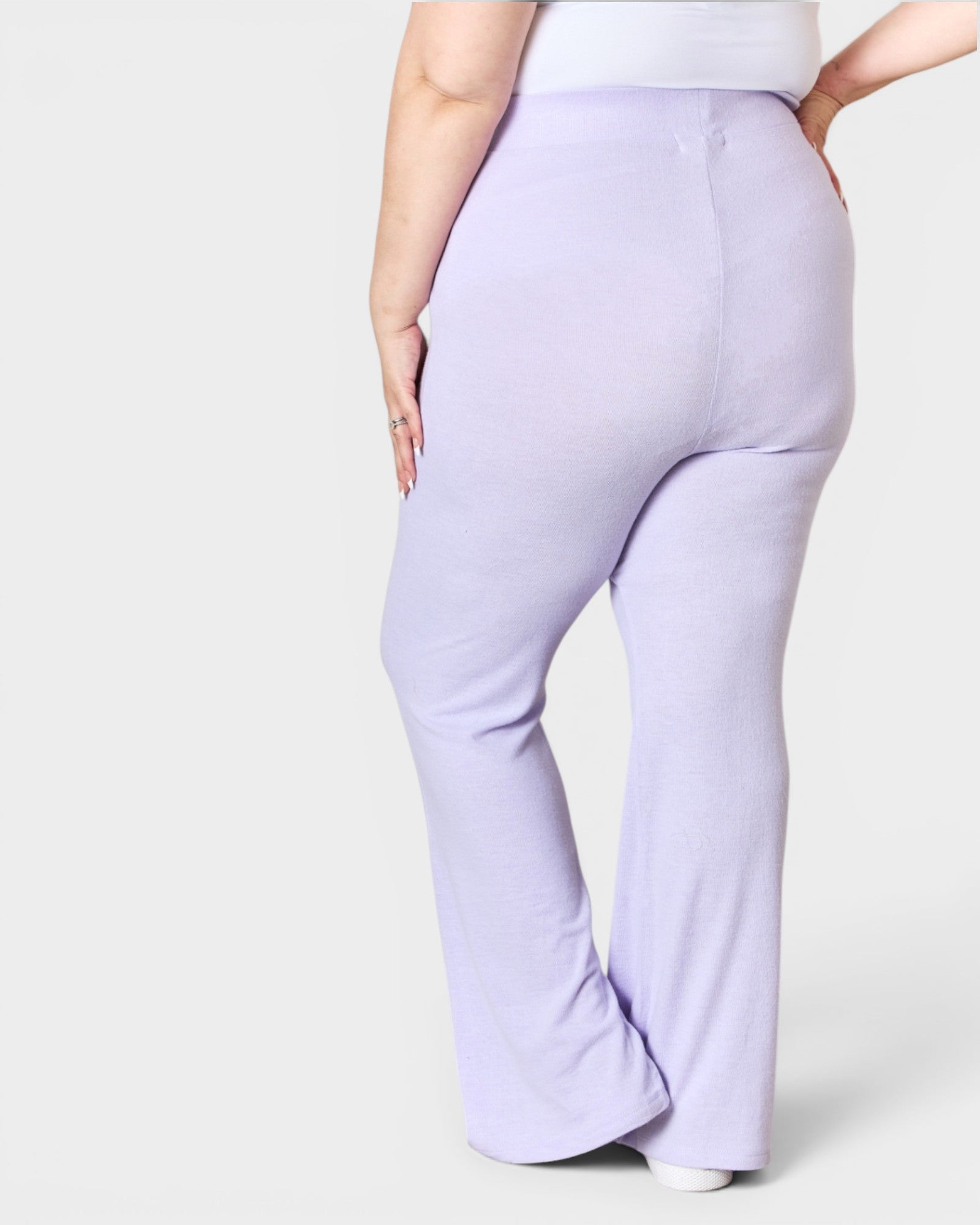 Lavender flared pants worn by a person on a white background