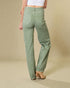 Person wearing green pants on a beige background