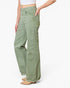 A model wearing sage green wide-leg jeans with a frayed hem, paired with a white crop top and tan boots, shown from the waist down on a white studio background.