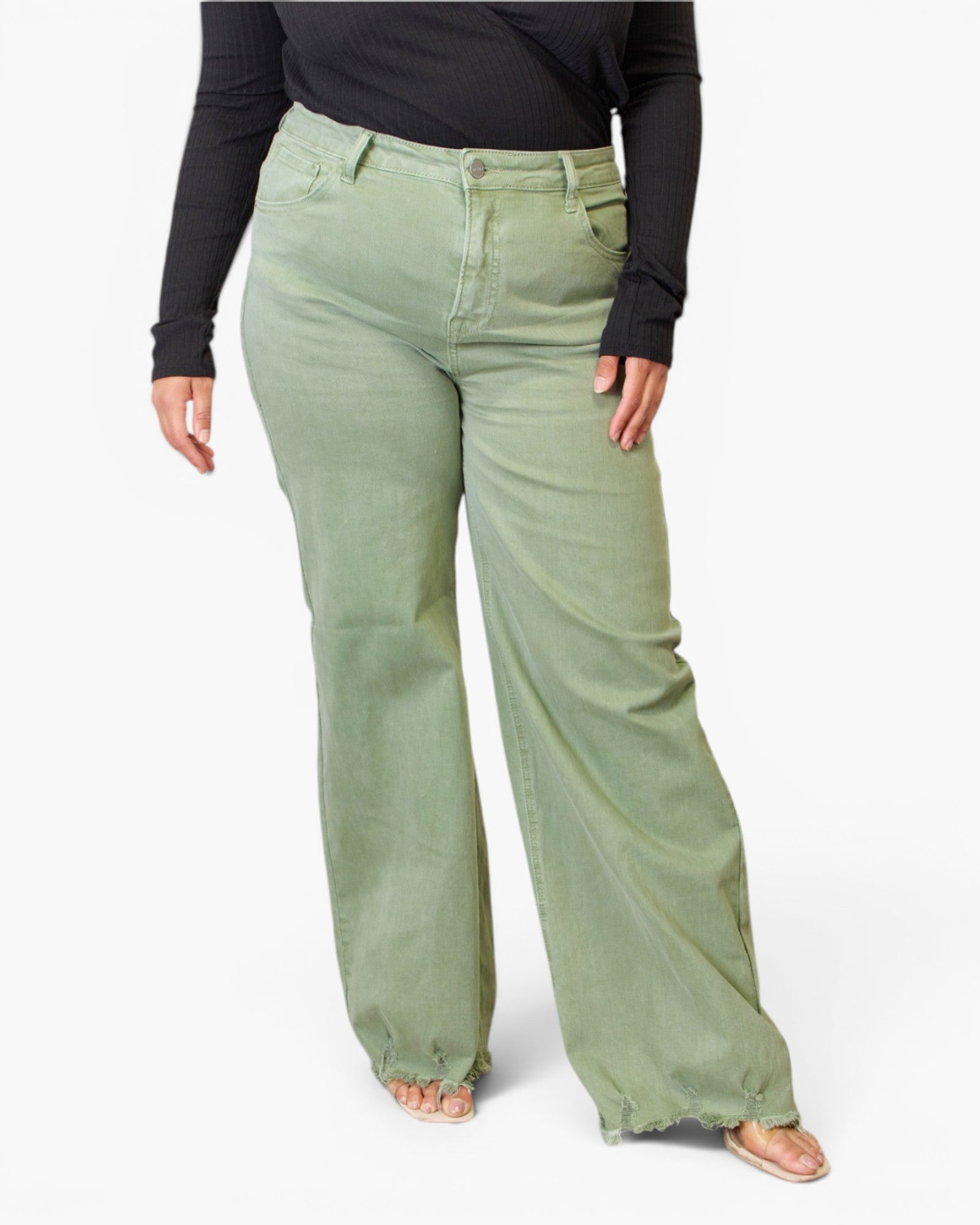 A model wearing sage green wide-leg jeans with a black long-sleeve top and beige flat sandals, shown from the waist down against a plain white background.
