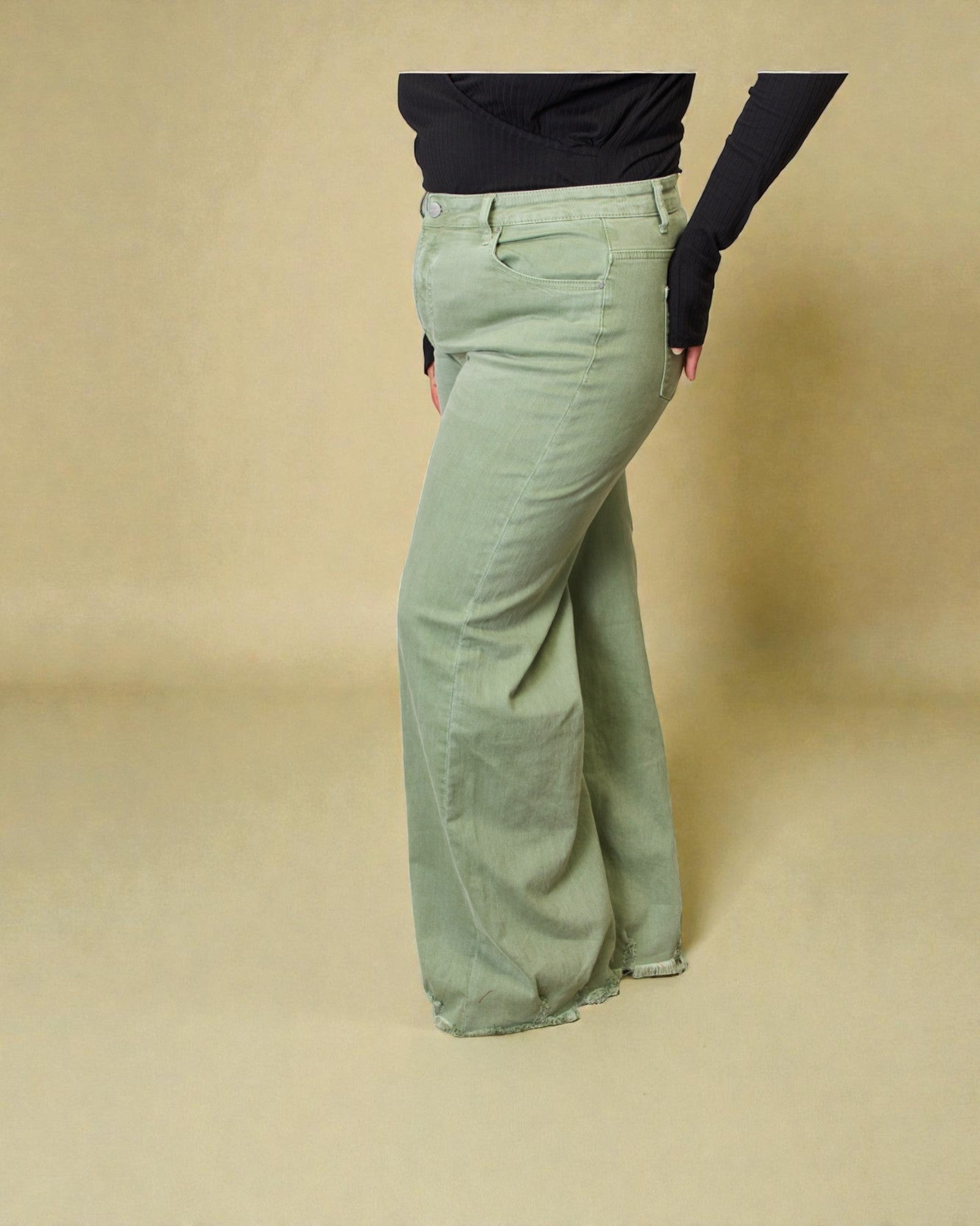 Person wearing light green wide-leg pants on a beige background