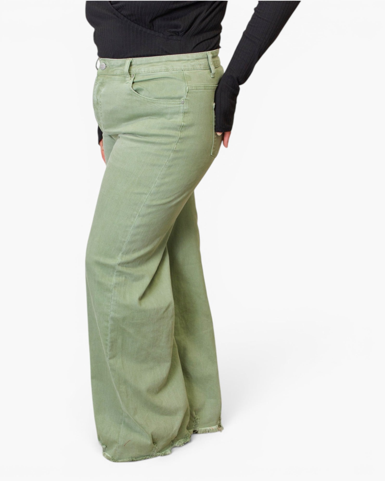 A person wearing sage green wide-leg pants and a black long-sleeve top, shown from the waist down against a plain white studio background.