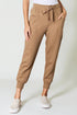 Tan jogger pants worn by a person on a white background
