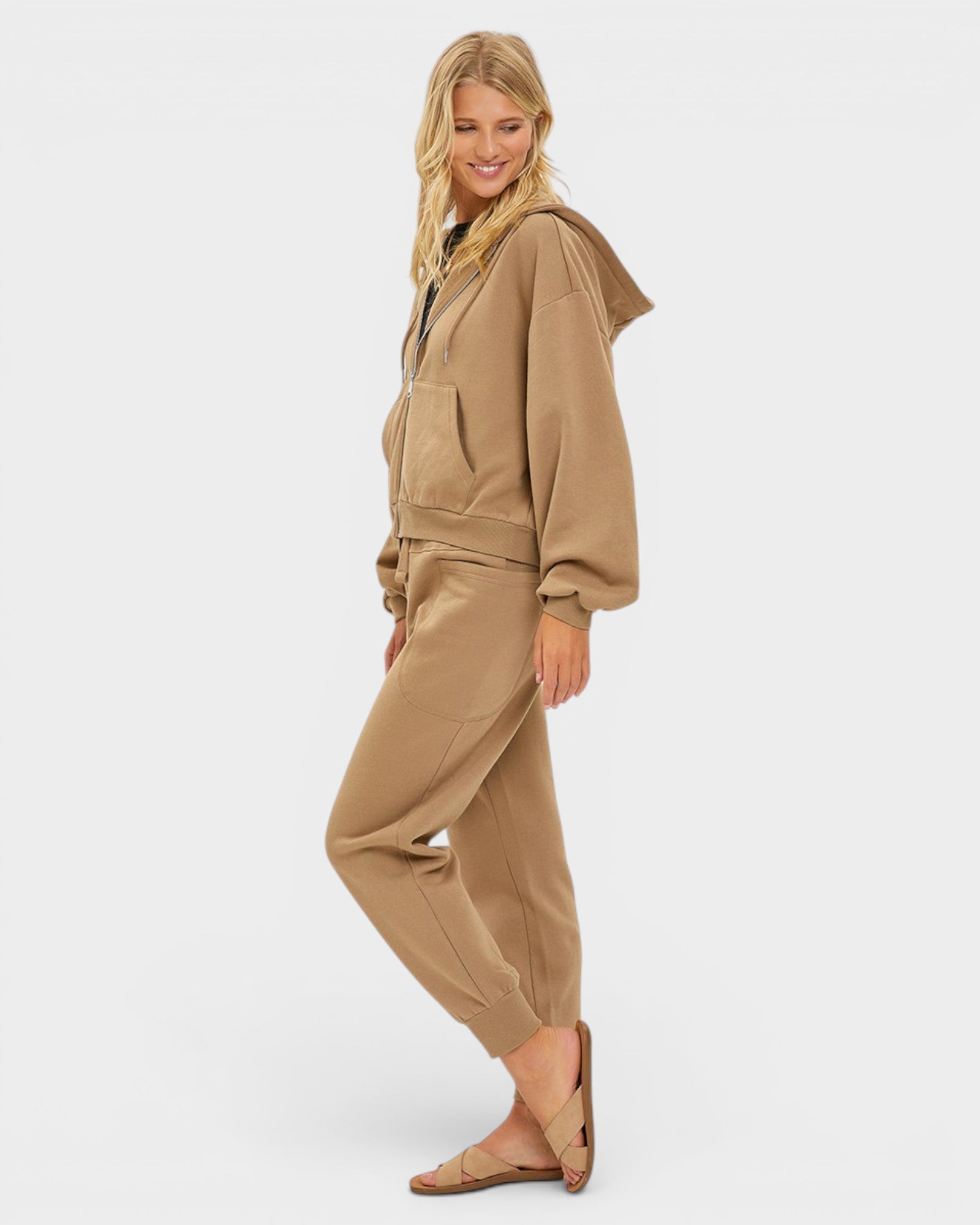 Woman wearing a beige tracksuit on a white background