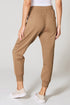 Person wearing tan jogger pants on a white background
