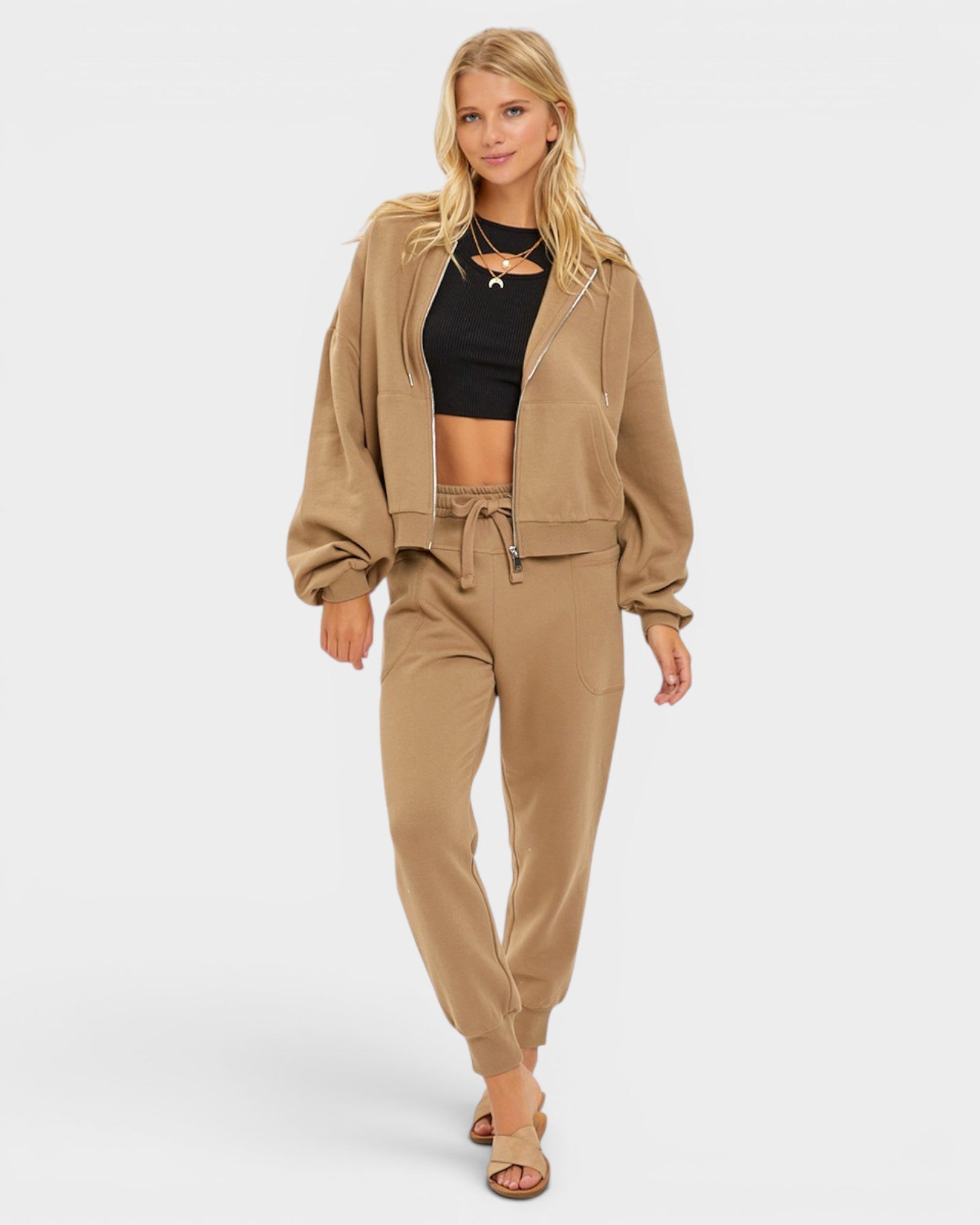 Woman wearing a beige tracksuit on a white background