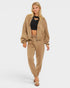 Woman wearing a beige tracksuit on a white background