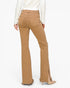 A person shown from the back wearing tan flared jeans with side slits and frayed hems, paired with a white long-sleeve top and beige heels, against a light gray studio background.