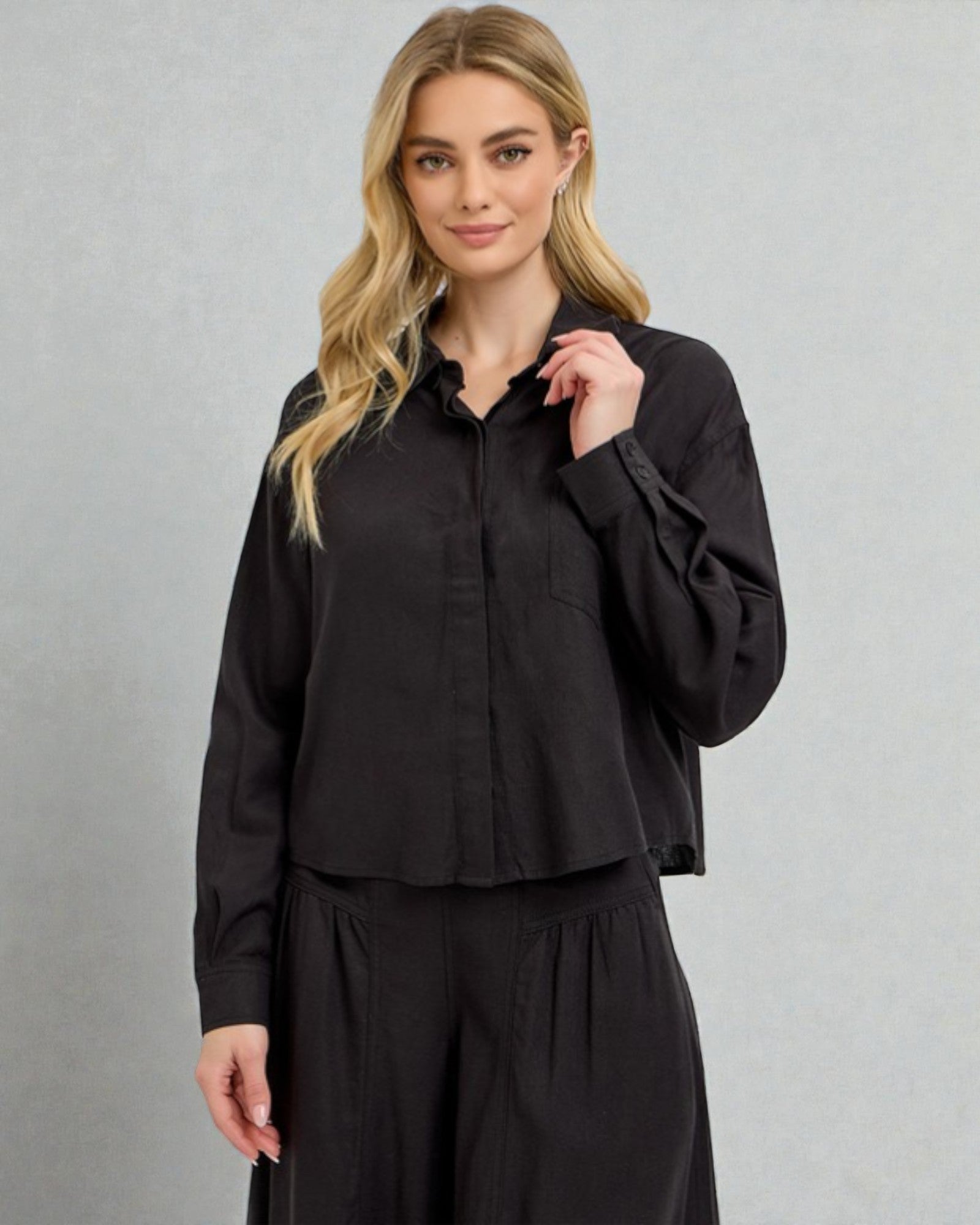 Woman wearing a black outfit against a gray background