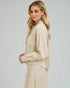 Woman wearing a beige suit against a plain background