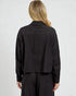 Person wearing a black long-sleeve shirt against a white background