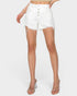 White denim shorts with a button fly and raw frayed hems, modeled on a person against a light gray studio background.