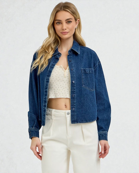 Woman wearing a blue denim jacket over a white lace top and pants on a white background