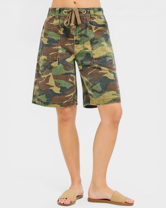 Camouflage shorts worn by a person on a white background