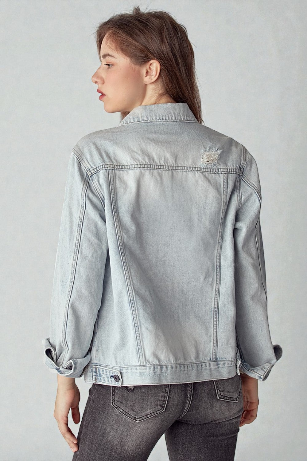 Light blue denim jacket worn by a person on a plain background