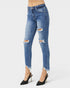 Blue distressed jeans worn by a person on a white background