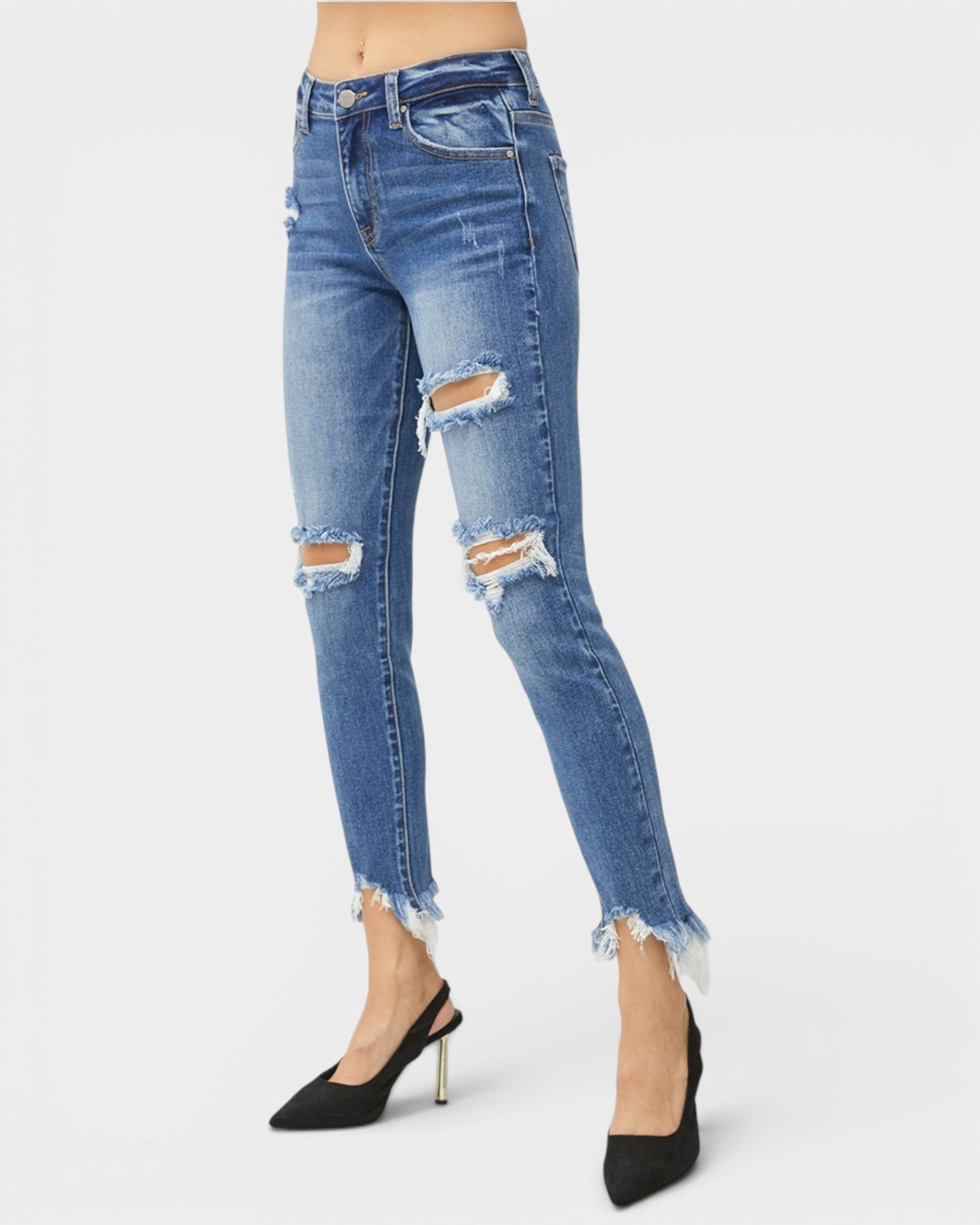 Blue distressed jeans worn by a person on a white background