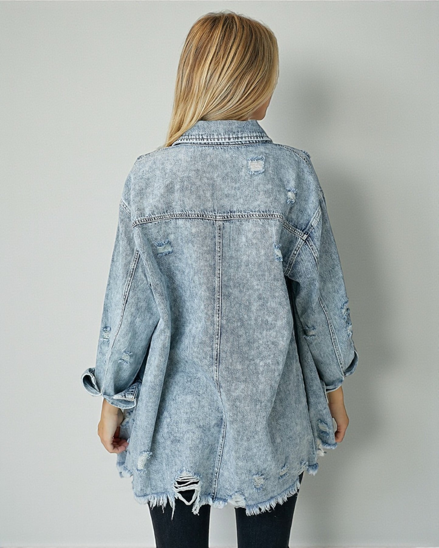Light blue denim jacket worn by a person on a plain background