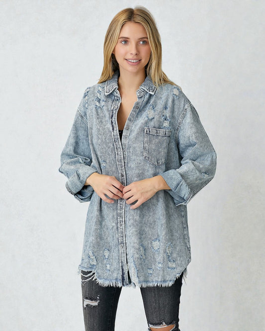 Woman wearing a light blue distressed denim jacket on a white background