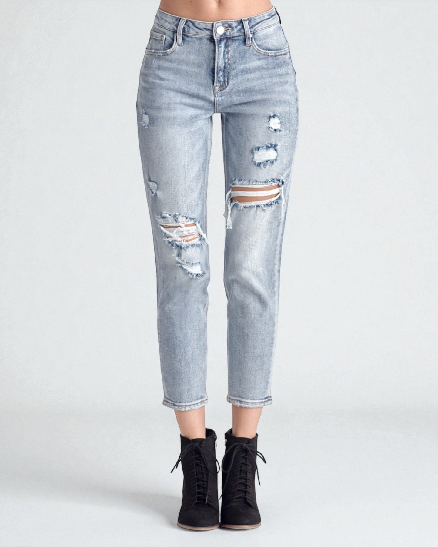 Light blue distressed jeans worn by a person on a white background