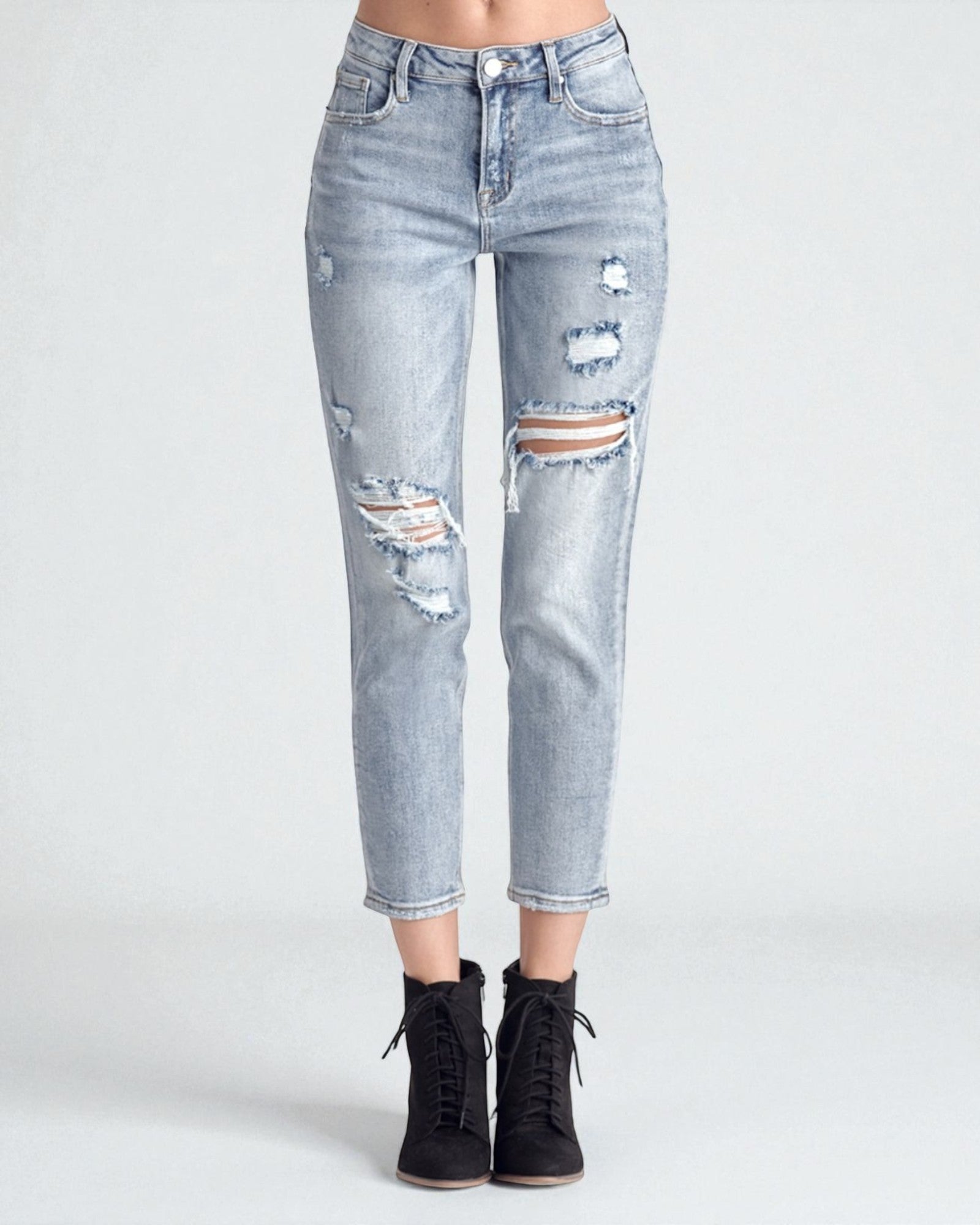 Light blue distressed jeans worn by a person on a white background