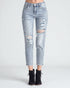 Light blue distressed jeans worn by a person on a white background