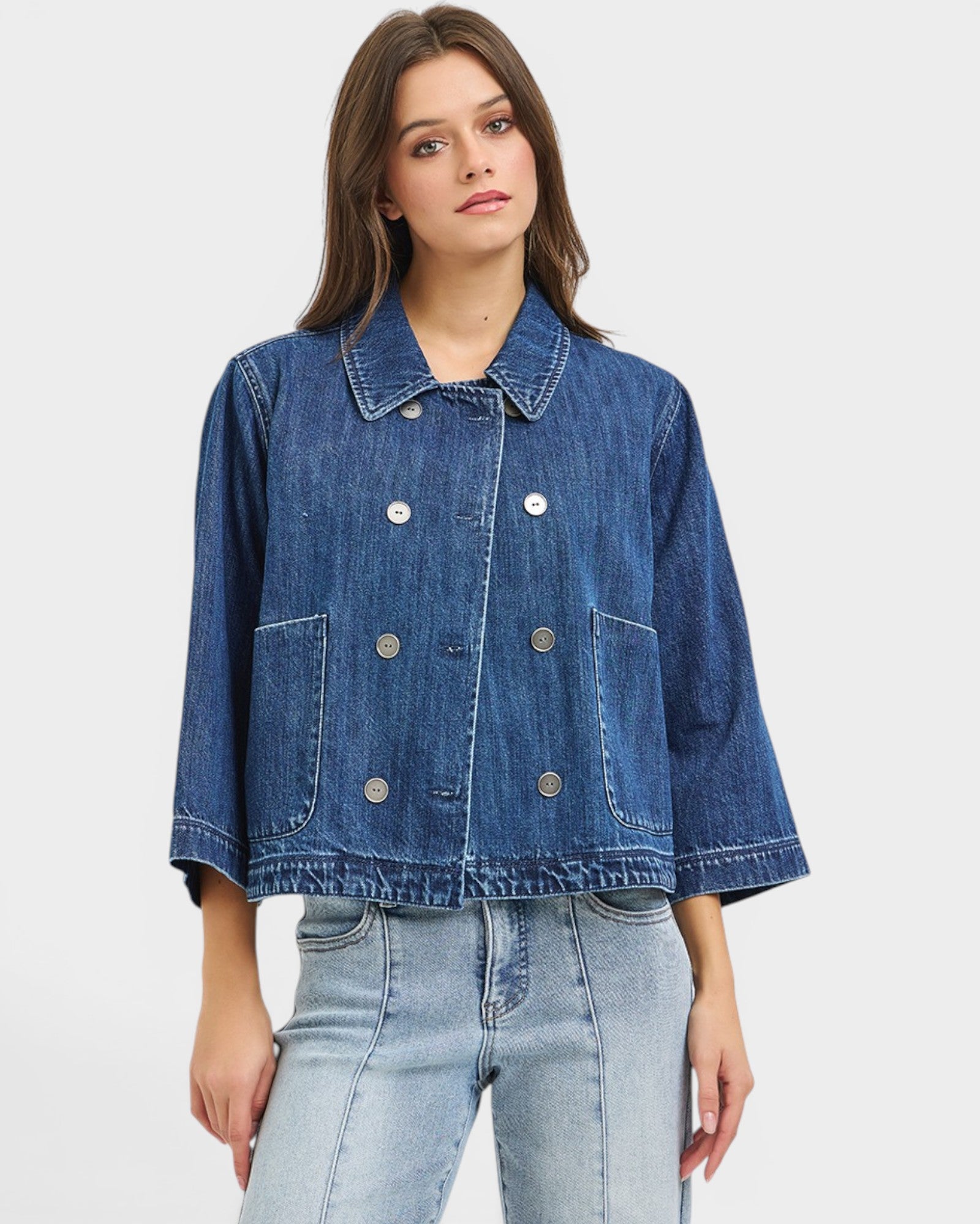 Woman wearing a blue denim jacket on a white background