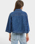 Person wearing a blue denim jacket on a light gray background